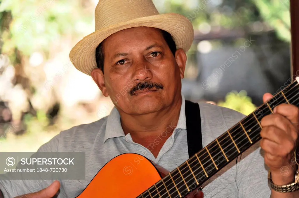 Cuban musician holding a guitar, employee of Jardin Botanico de Cienfuegos, Botanical Garden of Cienfuegos, Cuba, Greater Antilles, Caribbean, Central...