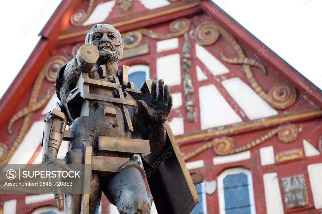 Statue of Goetz von Berlichingen by Gunther Stilling in front of the ornate half-timbered building of the Old Town Hall, Jagsthausen an der Jagst, Hoh...