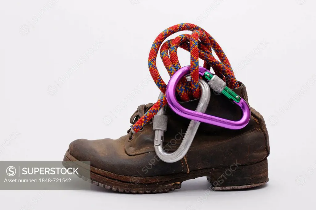Old mountain boots with nailed soles and iron heels, with a climbing rope and carabiner