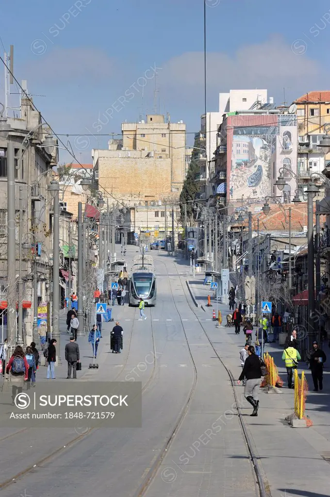 Street scene on the Jaffa Road with Orthodox Jews and the rails of the new tram line, light rail, and a mural of the new tram on a wall, Jerusalem, Is...