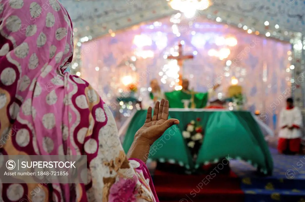 Veiled woman with her hands open in prayer, mass in the Parish Church of St. John, Christian community of Youhanabad, Lahore, Punjab, Pakistan, Asia