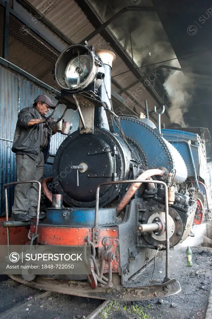 Historic train being repaired by worker, Darjeeling Himalayan Railway, narrow-gauge railway, Toy Train, UNESCO World Heritage Site, Darjeeling, West B...