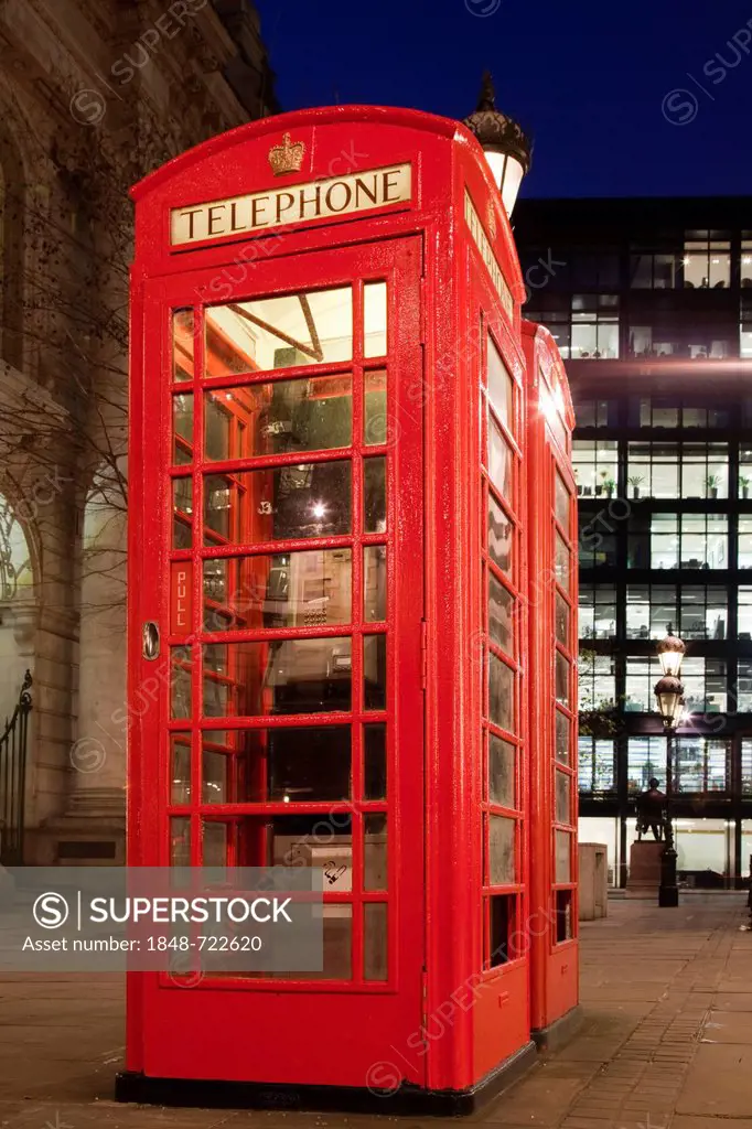 Red telephone booth in the City of London at night, London, England, United Kingdom, Europe