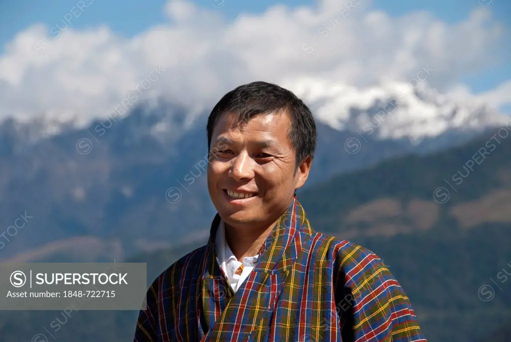 Man smiling, portrait, wearing traditional Gho dress, plaid fabric, the Himalayas, Bhutan, South Asia, Asia