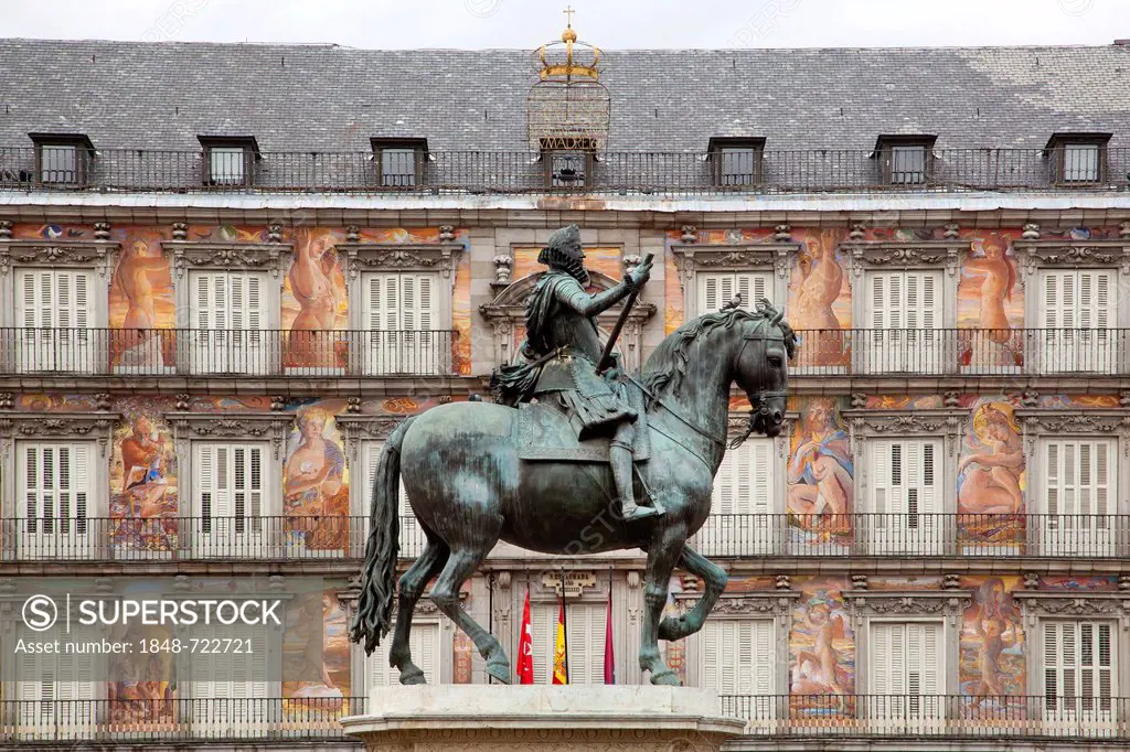 Historic town square of Plaza Mayor with an equestrian statue of Philip III by Giovanni Bologna in front of the frescoed Casa Panaderia, Madrid, Spain...