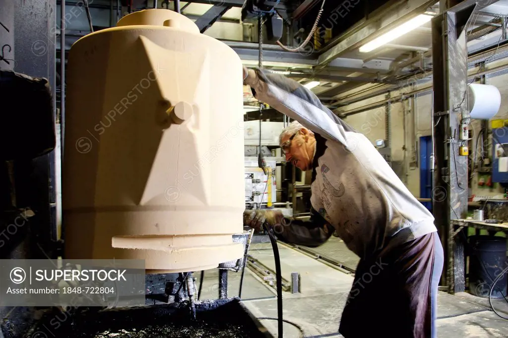 An employee of Luitpoldhuette AG, a foundry that specializes in the casting of engine blocks, motor parts and refrigeration compressors, making a core...