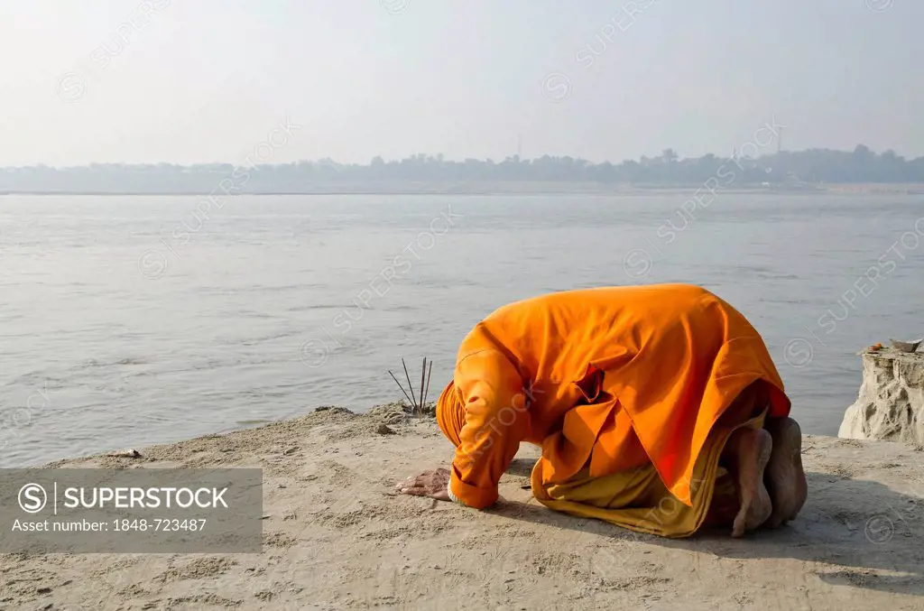 Sadhu, holy man, praying at Sangam, the confluence of the holy rivers Ganges, Yamuna and Saraswati, in Allahabad, Uttar Pradesh, India, Asia