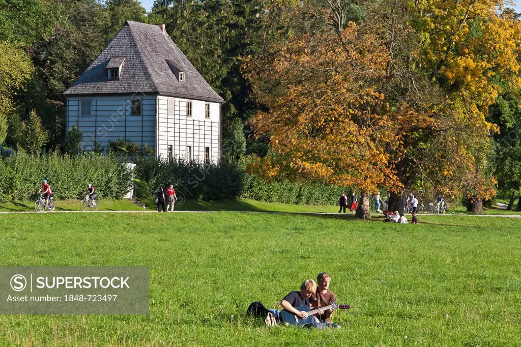 Young people playing guitar in front of Goethe's Garden House, Park an der Ilm, Weimar, Thuringia, Germany, Europe
