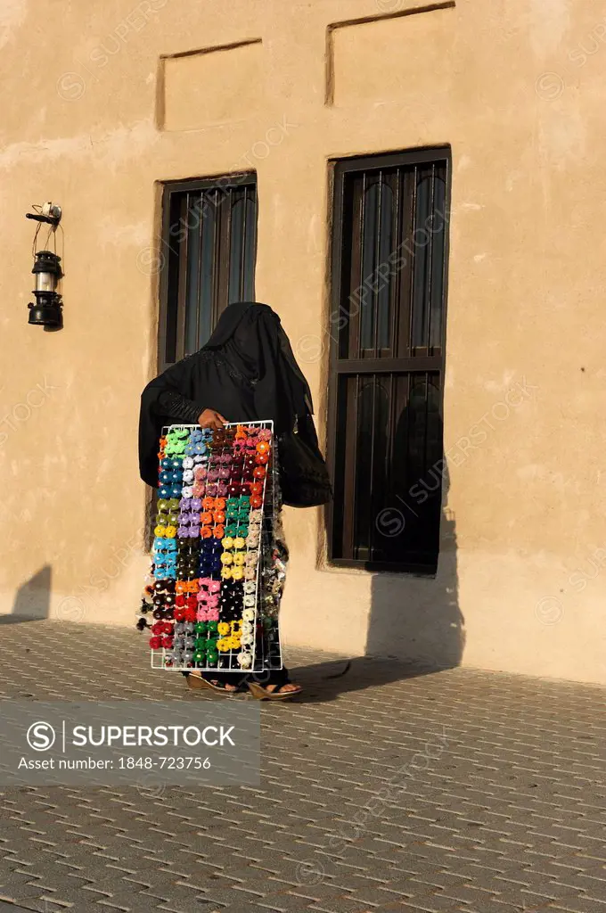 Veiled Arabian woman carrying embroidery yarn, Al Schindagha, Dubai, United Arab Emirates, Arabian Peninsula, Middle East, Asia