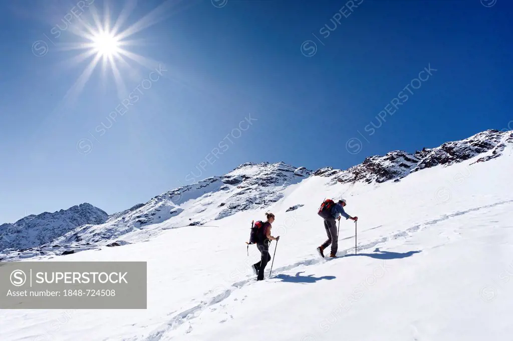 Hikers on Weissbrunnferner Mountain while ascending Hintere Eggenspitze Mountain in the Ulten Valley with the summit of Hintere Eggenspitze Mountain a...