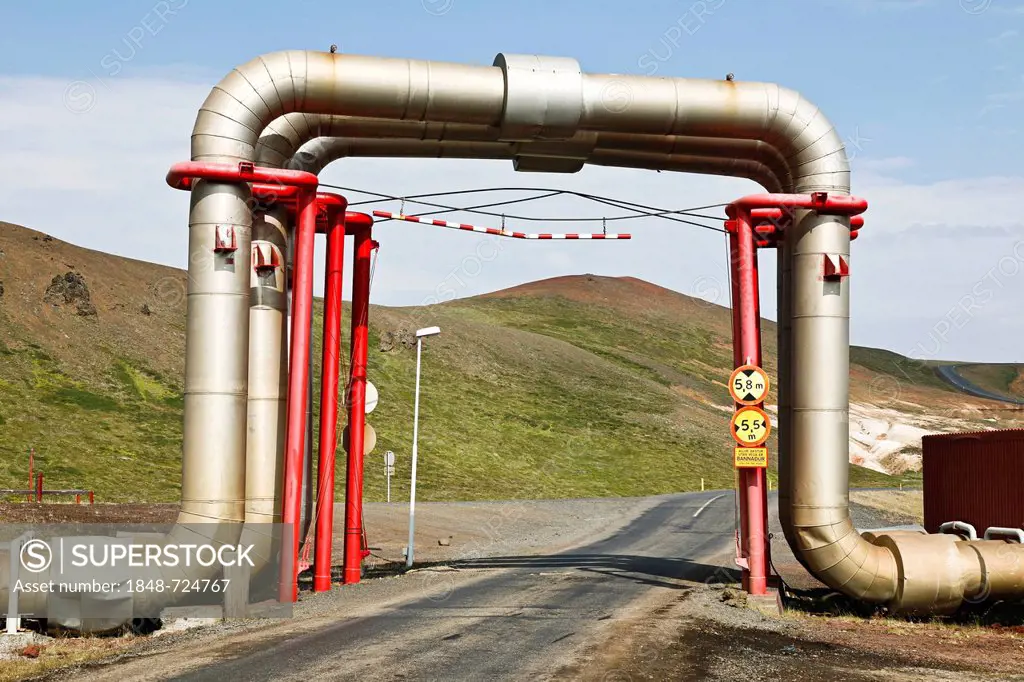 Road underneath a bridge of pipes and pipelines carrying hot water from the Kroefluvirkjun geothermal power plant, geothermal area of the Leirhnjukur ...