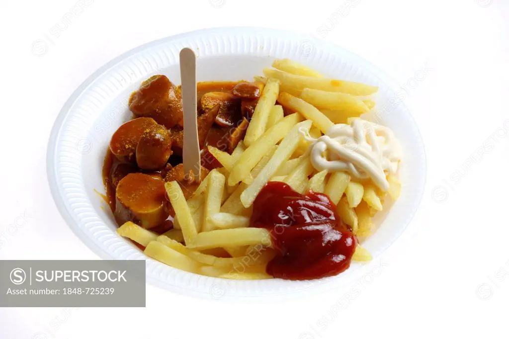Fast food, French fries and sausage with curry powder on a paper plate with ketchup and mayonnaise