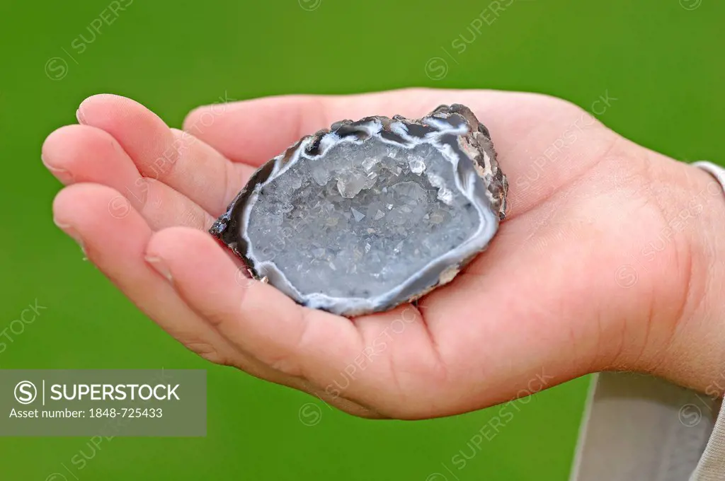 Crystalline quartz in a geode held in a hand, charmstone, precious stone