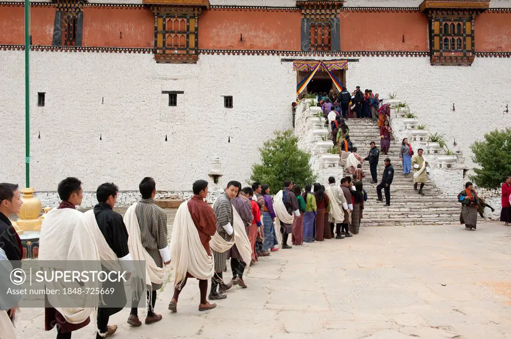 Tibetan Buddhist festival, people wearing the traditional Gho robe standing in a queue, Rinpung Dzong Monastery and Fortress, Paro, Himalayas, Bhutan,...