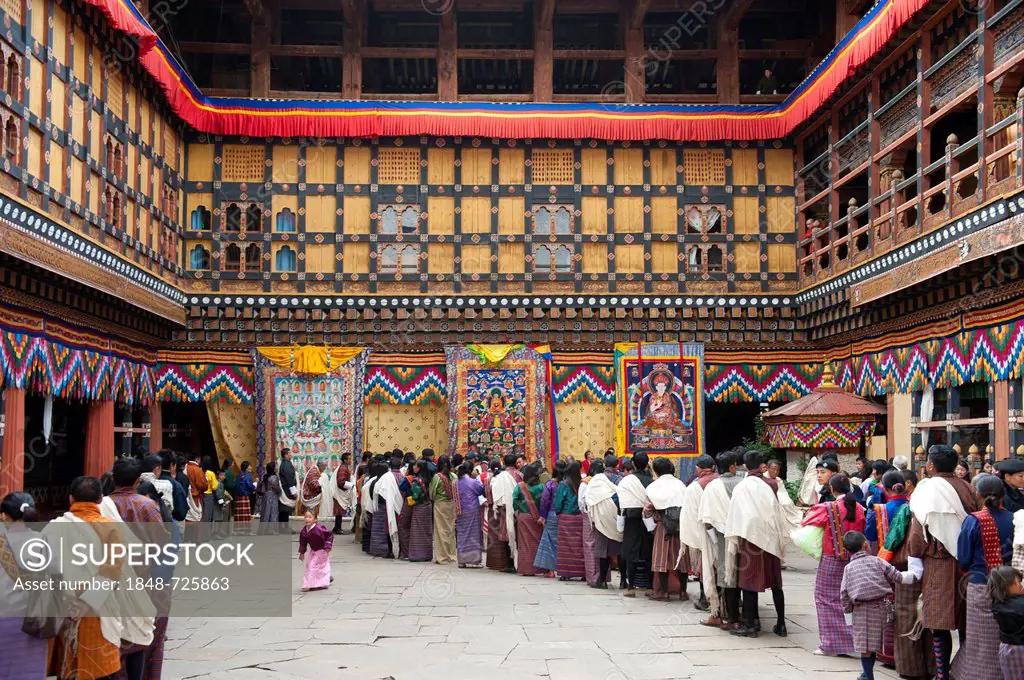 Tibetan Buddhist festival, people wearing the traditional Gho robe standing in a queue, Rinpung Dzong Monastery and Fortress, courtyard, Paro, Himalay...