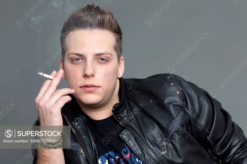 Young man in a leather jacket smoking a cigarette, portrait