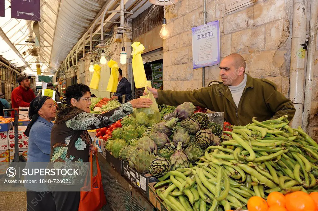 Jewish vendor offering a variety of fresh vegetables, including beans and artichokes, for sale on a stall at the Jewish Mahane Yehuda market, Jaffa Ro...