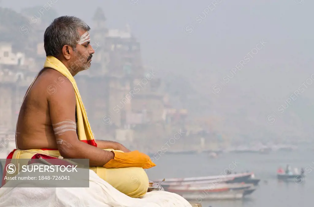 Brahmin man meditating at the holy river Ganges in the morning, Varanasi, Uttar Pradesh, India, Asia