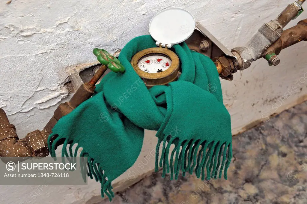 Water meter with a scarf in a basement, symbolic image for protection against frost