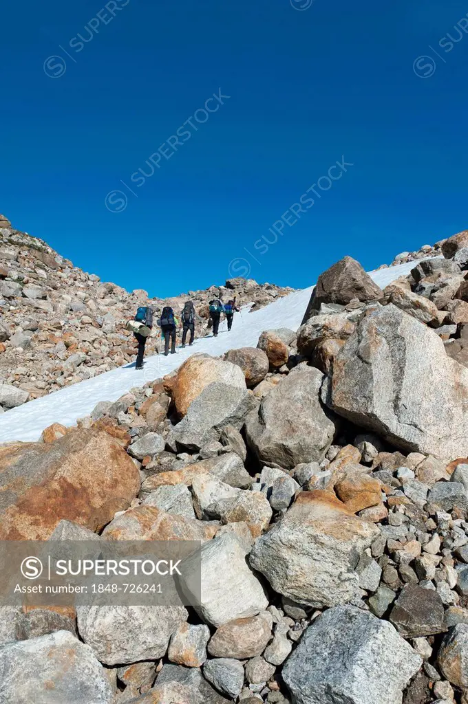 Field of snow and boulders, hikers at Mittivakkat Glacier, Ammassalik Peninsula, East Greenland, Greenland