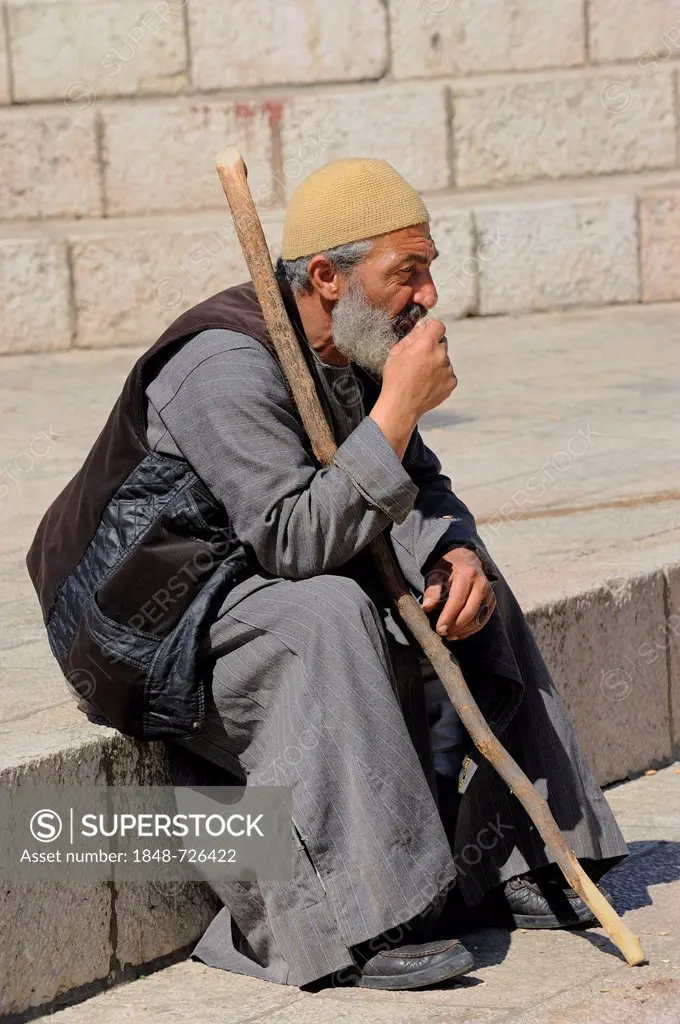 Palestinian man sitting on the steps outside the Damascus Gate in front of the Old City, Jerusalem, Israel, Middle East, Southwest Asia