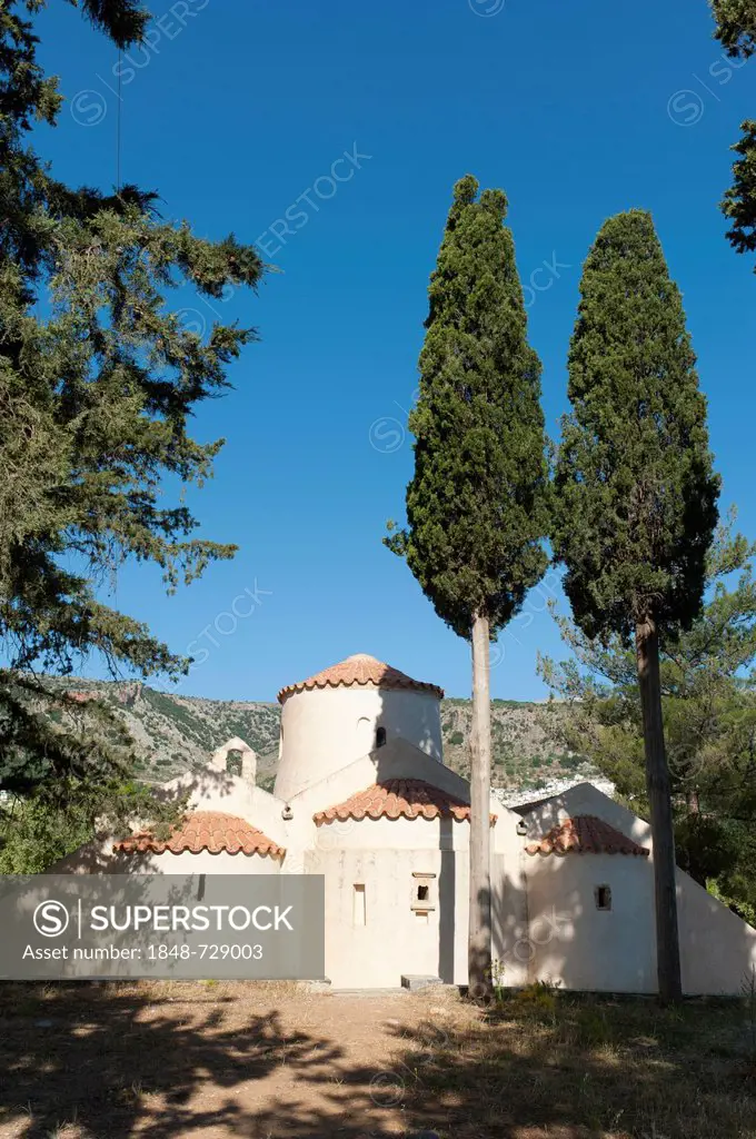 A three-aisled Greek Orthodox domed church, rear side, Monastery of Panagia i Kera, two tall Cypress trees (Cupressus) in the foreground, Kritsa, Cret...