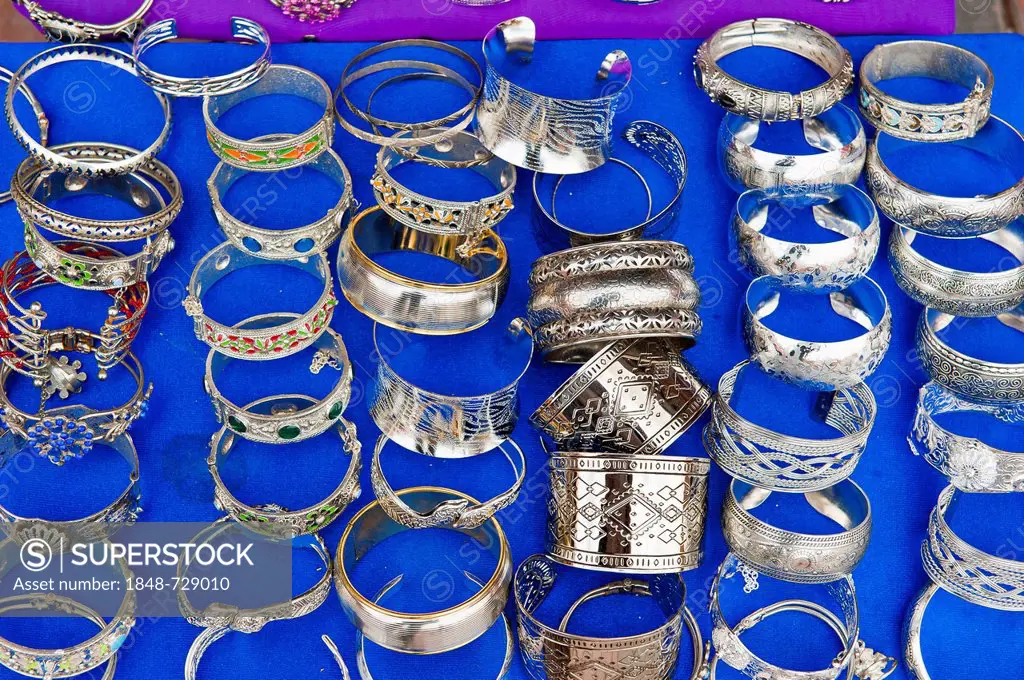 Ornately decorated silver bangles on a blue cloth for sale, souks, bazaar area, Marrakech, Morocco, Africa