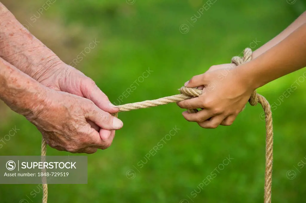 Elderly woman and a child pulling on a rope