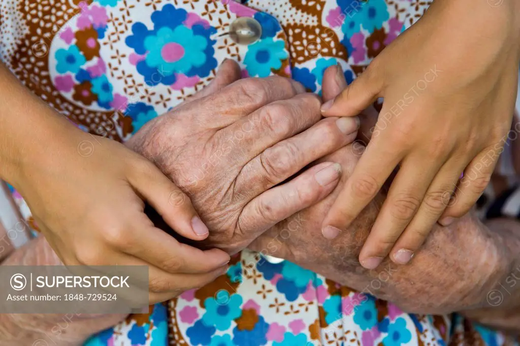 Child hugging an elderly woman, detail of hands
