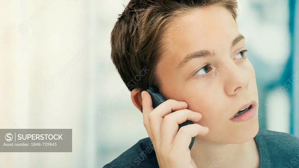 Portrait, boy, teenager concentrating while talking on a mobile phone