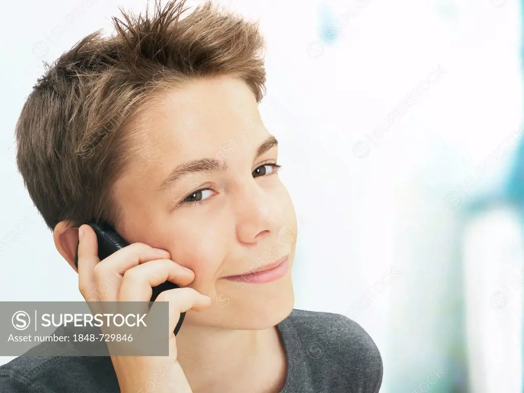Portrait, boy, teenager talking on a mobile phone, smiling