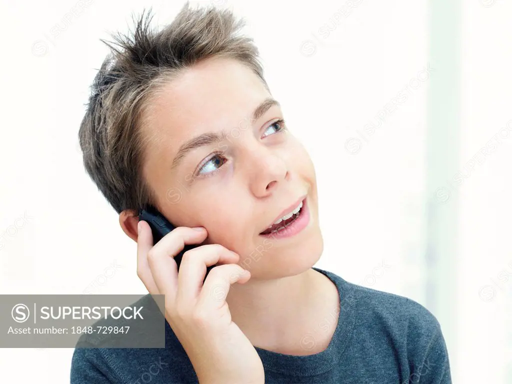 Portrait, boy, teenager talking on a mobile phone