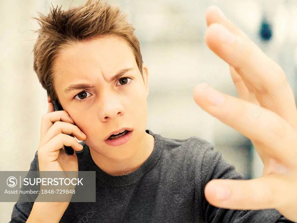 Portrait, boy, teenager looking angry while talking on a mobile phone