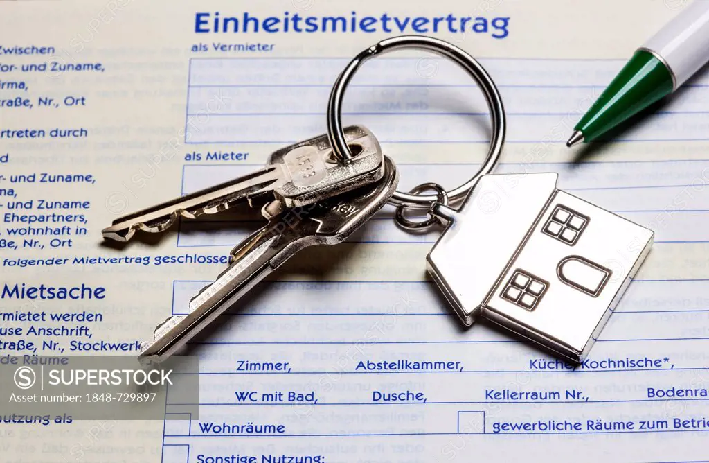 Two keys with a metal key tag shaped like a house lying on a German rental agreement, symbolic image for home, real estate, house purchase