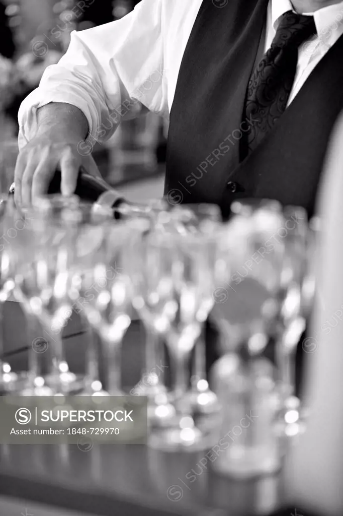 Waiter pouring champagne into champagne glasses