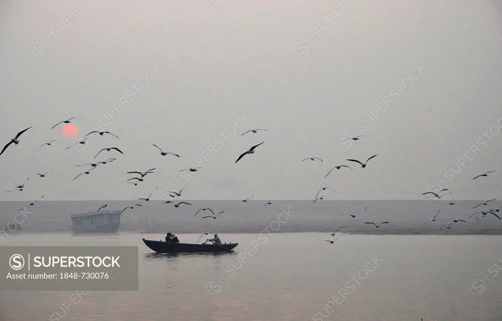 Believers in a boat at dawn on the Ganges River, Varanasi, Benares or Kashi, Uttar Pradesh, India, Asia