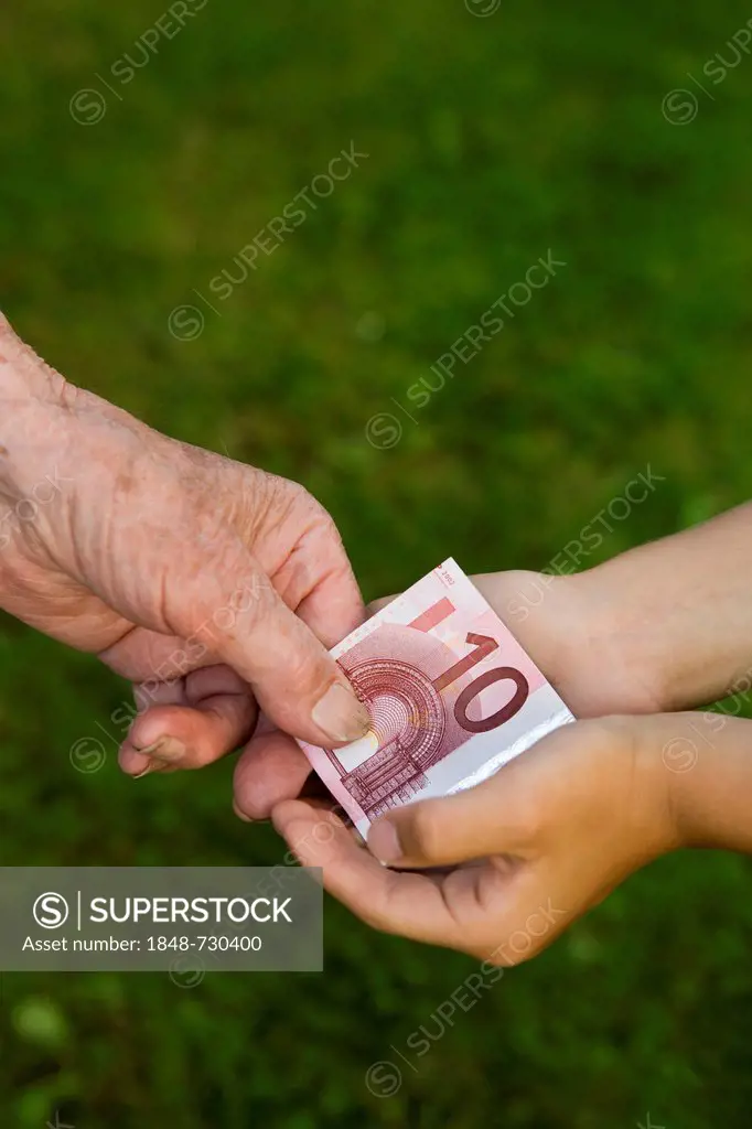 Elderly woman giving a child a 10-euro banknote
