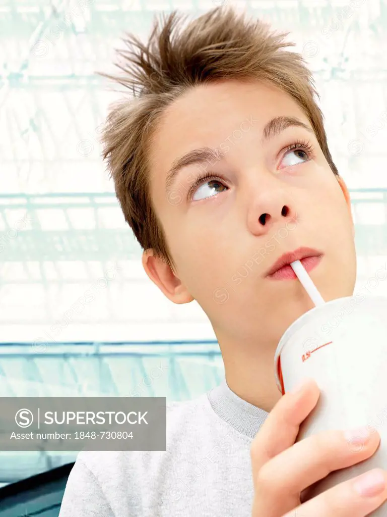 Portrait, boy, teenager drinking from a cup with a straw