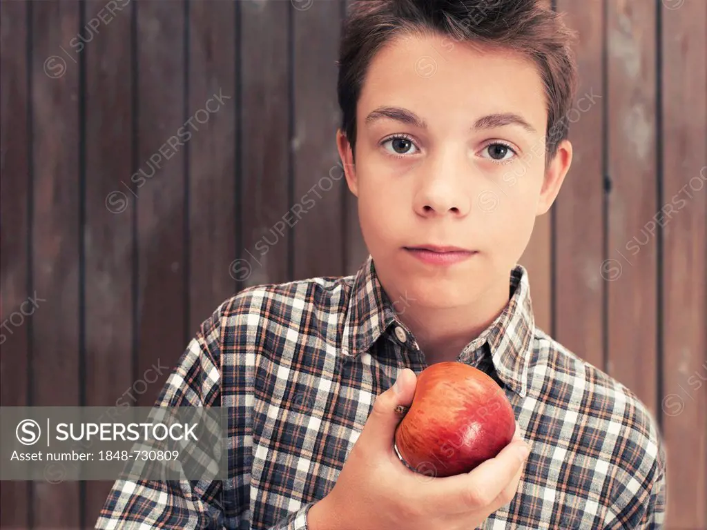 Portrait, boy, teenager eating an apple