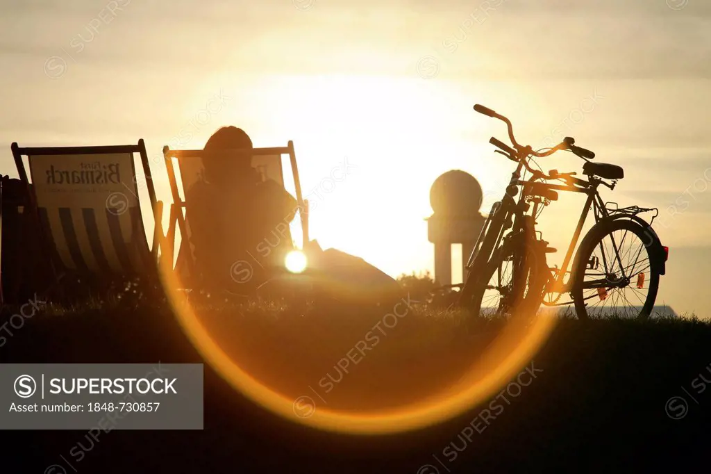 Person sitting in a deck chair, back lit, in a public park on the grounds of the former Berlin Tempelhof Airport, Berlin, Germany, Europe
