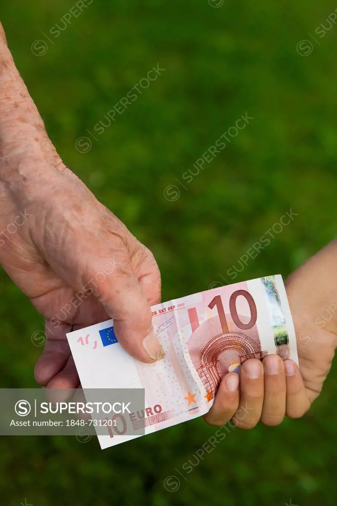 Elderly woman and a child holding a 10-euro banknote