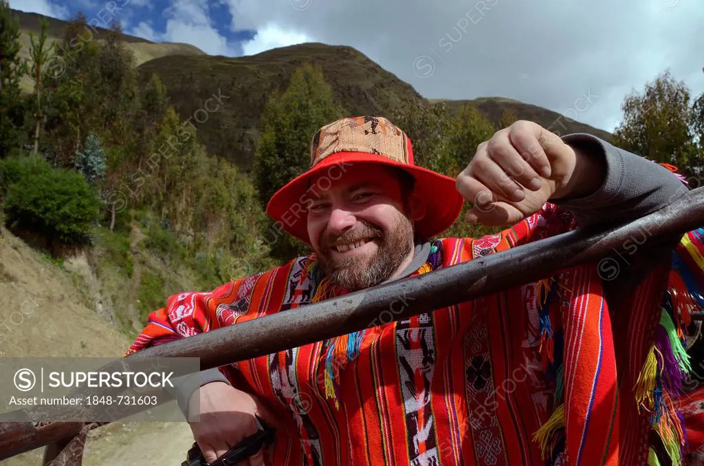 Tourist wearing a traditional poncho of the Quechua Indians riding in a truck, Andes, near Machu Picchu, Cusco, Peru, South America