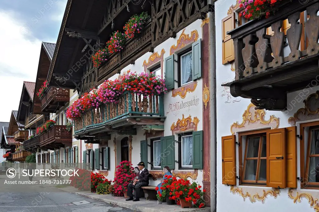 Houses with traditional mural paintings called Lueftlmalerei, balconies decorated with geraniums (Pelargonium), Sonnenstrasse street, Garmisch-Partenk...