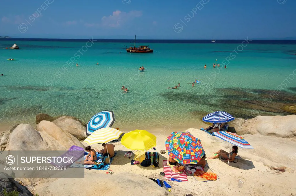 Tourists with parasols at the beach of Portokali, Kavourotypes, Sithonia, Chalkidiki or Halkidiki, Greece, Europe
