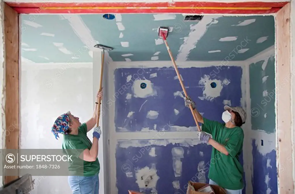 Jillian Robinson, left, and Patty Sanders, volunteers from the Marin Interfaith Council in California, repair a house damaged by Hurricane Katrina, Gr...