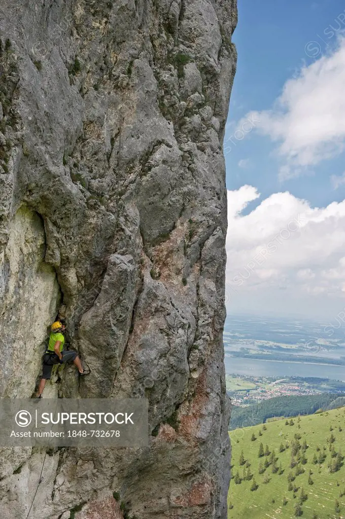 Climber on Mt Kampenwand, Chiemsee Lake at back, Chiemgau region, Bavaria, Germany, Europe