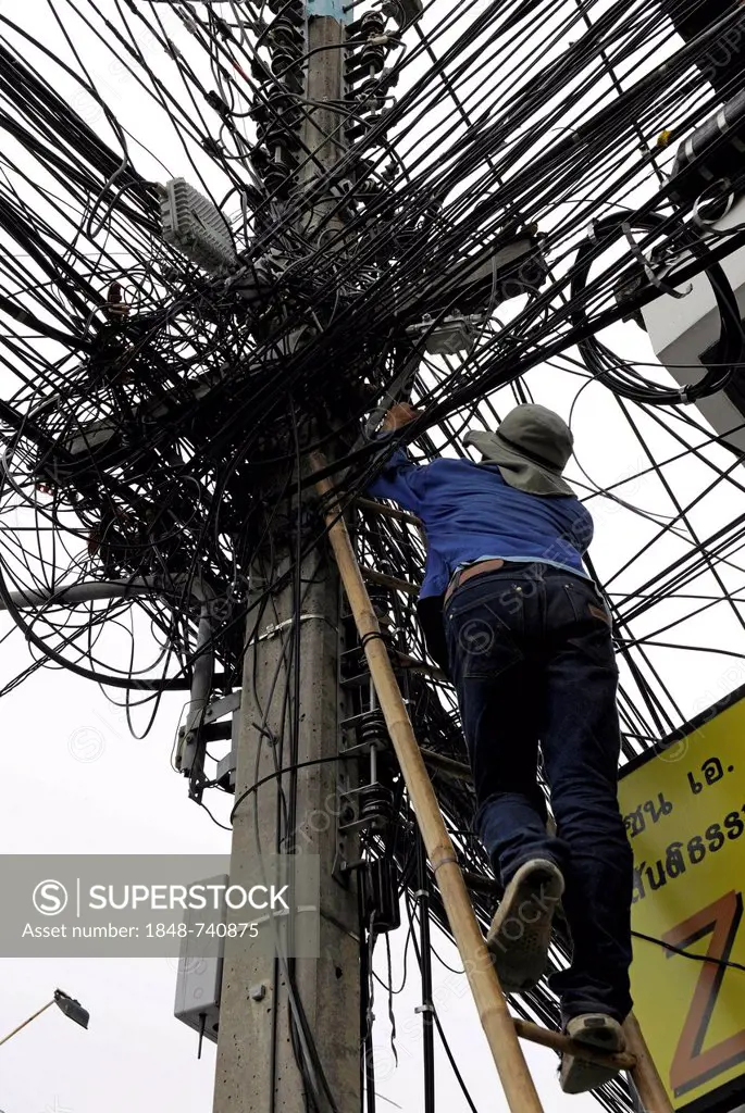 Man climbing up a ladder to fix power lines, pylon, Chiang Mai, Thailand, Asia