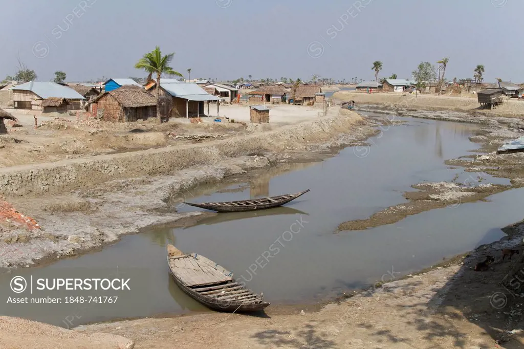 Two wooden boats in a desiccated floodplain, Cyclone Aila flooded the town of Gabura in 2009, the land is too salty to grow plants and buildings were ...