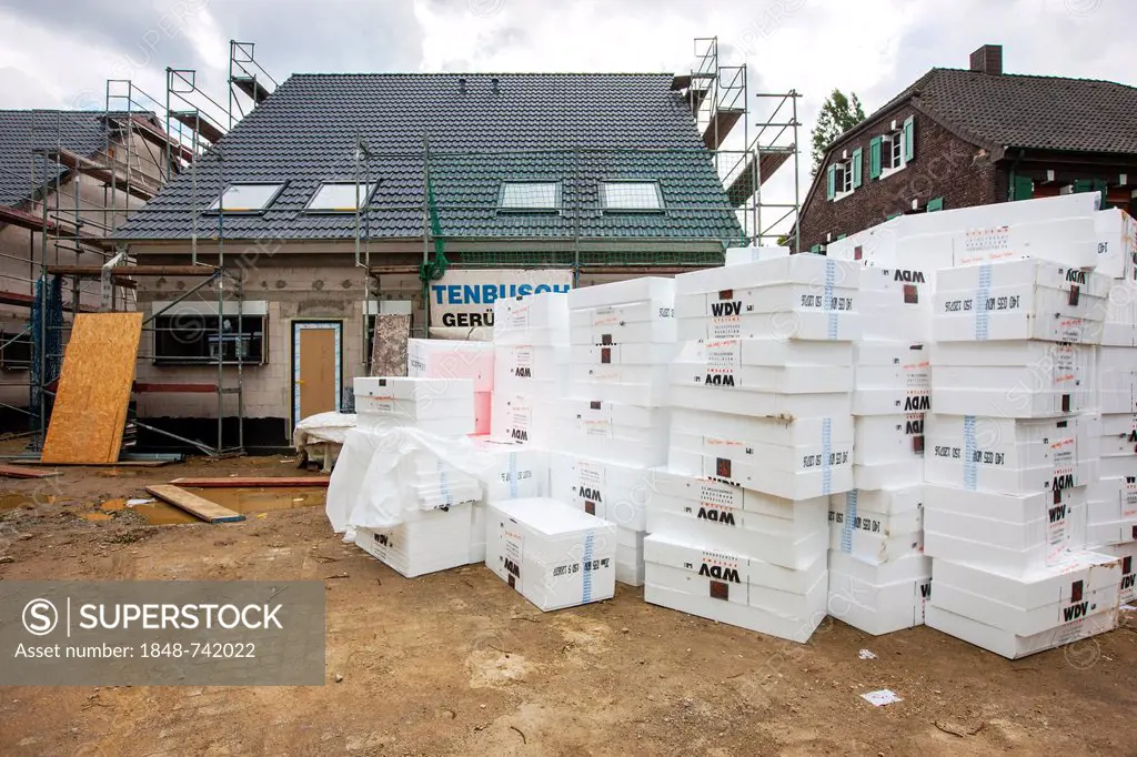 New construction of a single-family house, a stack of insulation material lying on the construction site