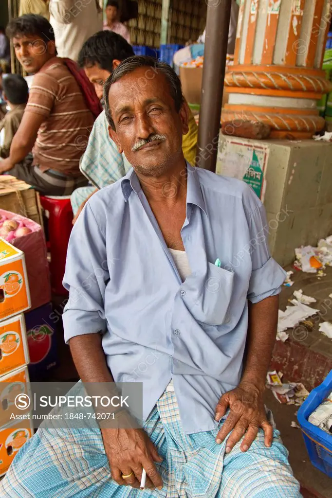 Market vendor at a stall during a cigarette break, Babu Bazar, Old Dhaka, Dhaka, Bangladesh, South Asia, Asia